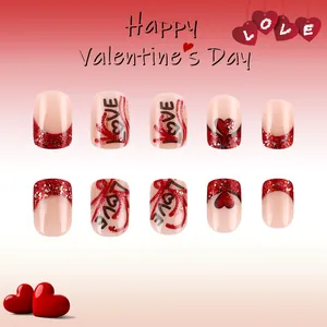 Detail of short heart-themed press-on nails with red glitter French tips and LOVE lettering