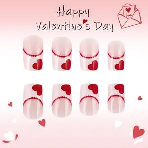 Detailed view of short glossy press-on nails with red heart patterns for Valentine's Day