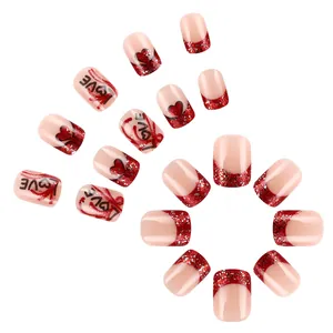 Short French press-on nails with red glitter tips, love letters, and heart patterns