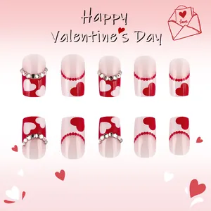 Detail of short round Valentine's nails with red hearts and sparkling rhinestones
