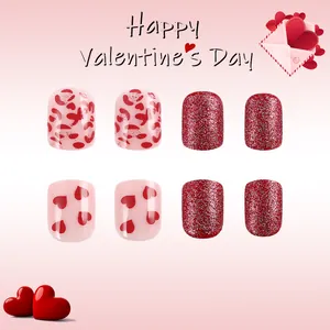 Short glossy press-on nails with red hearts, glitter, and leopard print designs