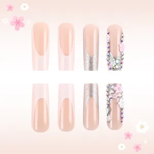 Détail de faux ongles avec French tips, fleurs 3D et strass brillants scintillants