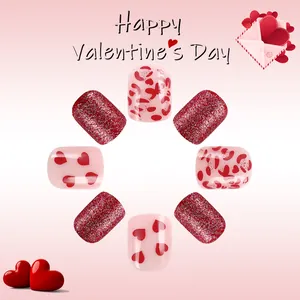 Short glossy press-on nails with red glitter and heart patterns for Valentine's Day