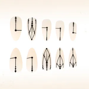 Detailed flat lay of matte almond press-on nails with black geometric line art patterns