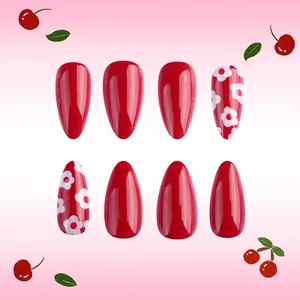 Detail of red cherry-themed press-on nails with floral patterns and glossy finish