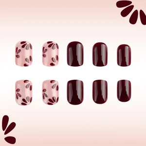 Detailansicht kurzer ovaler Kunstnägel mit dunkelrotem und rosa glänzendem Blumenmuster