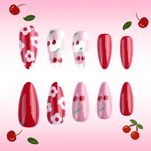 Detail of almond-shaped press-on nails with red cherry patterns and floral art