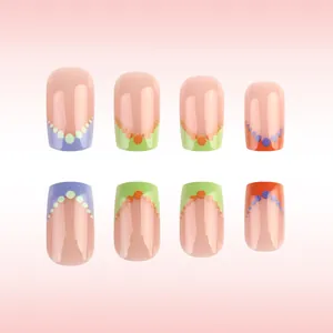 Detail of short square press-on nails with colorful French tips and glitter polka dots