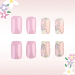 Detail of pink French press-on nails with floral patterns and white polka dots