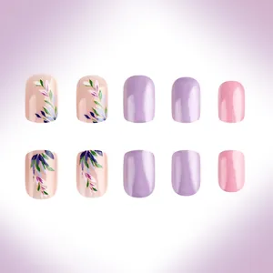 Detail of short square press-on nails with purple floral patterns and glossy pink finish