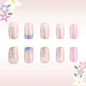 Detailed view of floral pink press-on nails with lavender french tips and leaf designs