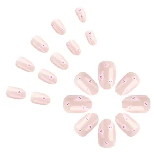Short nude pink press-on nails with white cherry blossom floral patterns and glossy finish