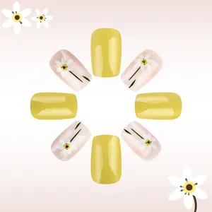 Glossy yellow press-on nails with white daisy floral design on a square-shaped tip