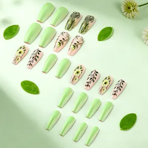 Detail of floral press-on nails featuring green tones, yellow flowers and matte finish