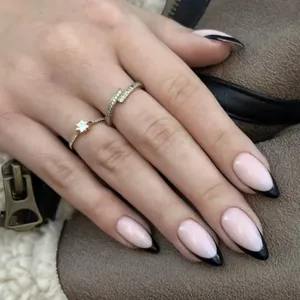 French black tip almond press-on nails with shiny finish and minimalist gold ring accents