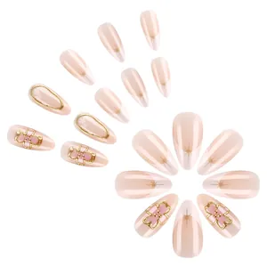 Elegant nude almond press-on nails with 3D pink flowers and gold starburst accents