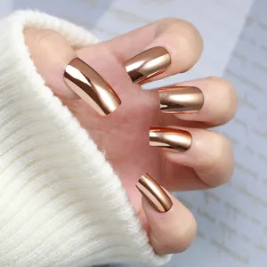 Close-up of rose gold mirror finish press-on nails on hand against white knit sweater