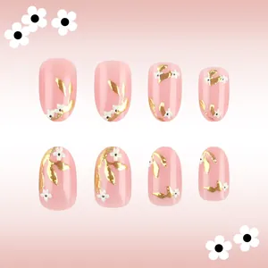 Short oval press-on nails in light pink with golden foil texture and white flower patterns