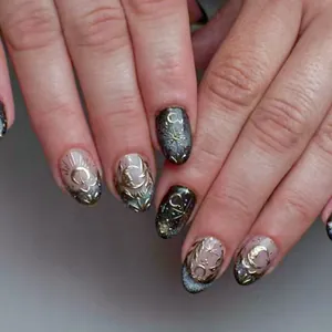 Dettaglio dei motivi celesti dorati in rilievo su unghie finte effetto cat-eye