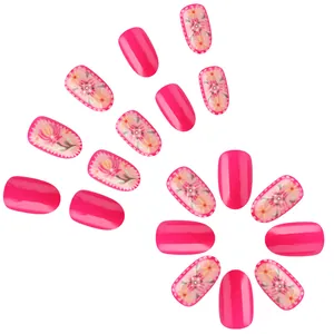 Pink glossy press-on nails with 3D embossed floral patterns and polka dot accents