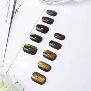 Detailed view of short square amber cat-eye press-on nails with golden glitter finish