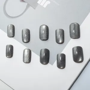 Detail of short square grey cat eye press-on nails with shimmering silver glitter finish
