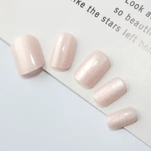 Détail de faux ongles carrés courts avec finition œil de chat scintillante rose pâle