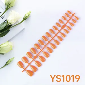 Glossy bright orange almond press-on nails set on plastic strips with white floral accents
