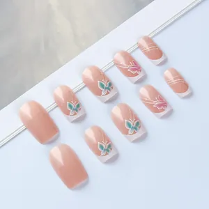 Détail de faux ongles nude avec motifs papillons et pointes de French manucure