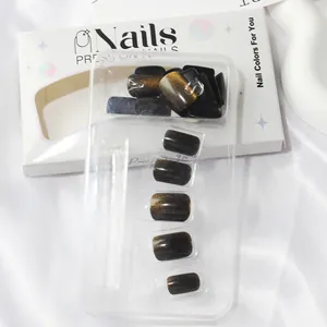 Close-up of short square brown cat eye press-on nails set with golden magnetic shimmer