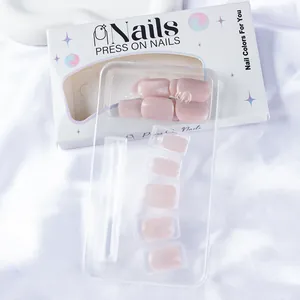 Détail de faux ongles œil-de-chat rose clair dans un emballage blanc sur du satin