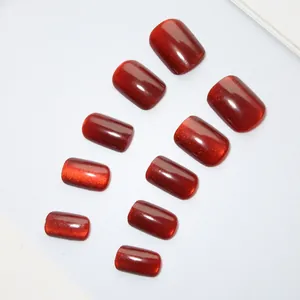Detailed view of glossy red cat-eye press-on nails with shimmering glitter finish