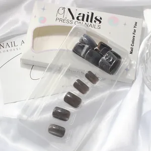 Detail view of cat-eye press-on nails in grey silver glitter with retail packaging