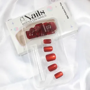 Detailed view of deep red cat eye press-on nails in elegant white branded packaging