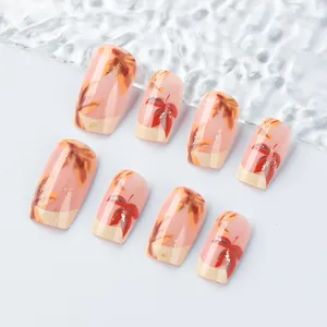 Detailed view of maple leaf French press-on nails with gold glitter on pink base