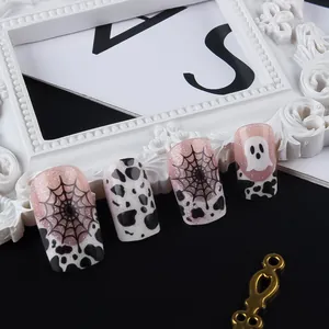 Dettaglio unghie finte di Halloween con ragnatele rosa glitterate e motivi di fantasmi