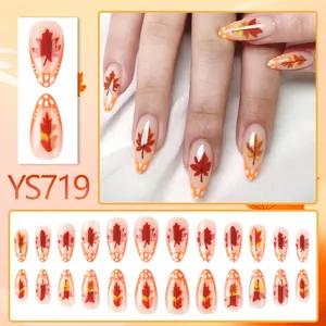 Glossy almond press-on nails with autumn maple leaf patterns in orange and beige