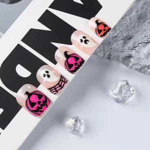 Close-up of Halloween short round false nails featuring pink pumpkin and ghost designs