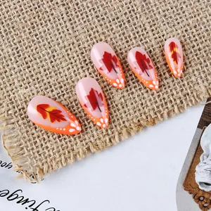 Glossy long almond press-on nails with autumn maple leaf design and orange French tips