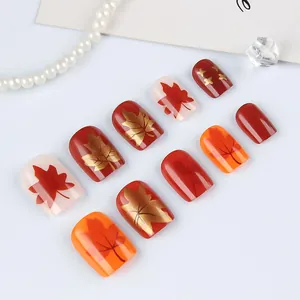 Uñas postizas de otoño con hojas de arce rojas y elegantes patrones de estrellas