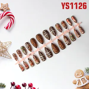 Detail van peperkoekman- en sneeuwvlokpatronen op 24 stuks bruine kerstkunstnagels op houder