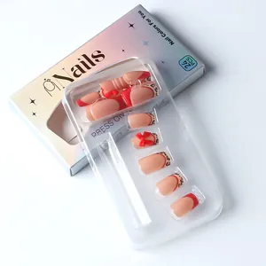 Macro detail of red leopard French nails with 3D bows and iridescent packaging box