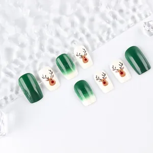 Close-up of green gradient Christmas press-on nails with brown reindeer patterns