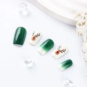 Close-up of square Christmas press-on nails featuring green elk and snowy gradient design