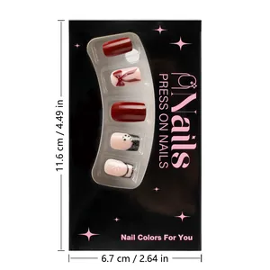 Detail of red press-on nails set with snowflakes and bow designs in branded box