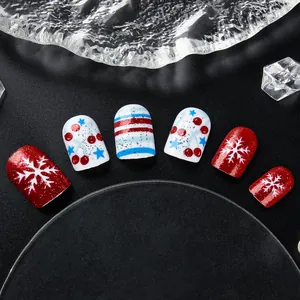 Detalle de uñas postizas navideñas rojas y azules con copos de nieve y purpurina