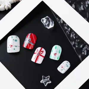 Detail of Christmas nail press-ons with festive ribbons and green tree patterns