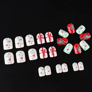 Christmas press-on nails set with red bows and holly designs on 24 piece square tips