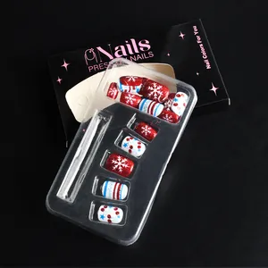 Detalle de uñas postizas brillantes de Navidad rojas y azules con copos en estuche