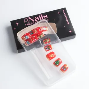 Detailed view of red Christmas press-on nails with tree patterns and glitter in gift box